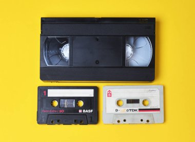 Belarus, Minsk - 05 / 12 / 2020: Sarı zemin üzerinde eski ses kasetleri BASF TDK ve video kasetleri. Retro tarzda yaratıcı konsept, 80 'ler. Üst görünüm, minimalizm.