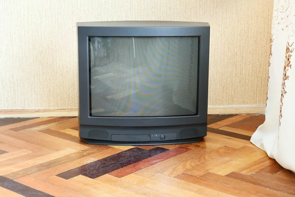 Vintage Television stands on a wooden parquet floor, old design in the house.