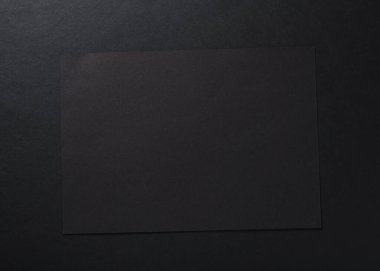 Siyah arkaplanda siyah bir sayfa. Siyah soyut desenli kağıt arka plan.