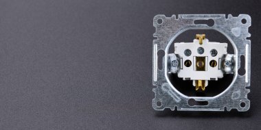 Elektrik İşleri ve Tamir Maliyetleri. Siyah arka planda sökülmüş soket. Minimalizm.