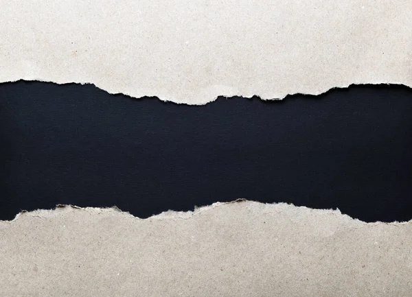 Dark paper with torn edges isolated on a black background of colored paper inside. Good paper texture