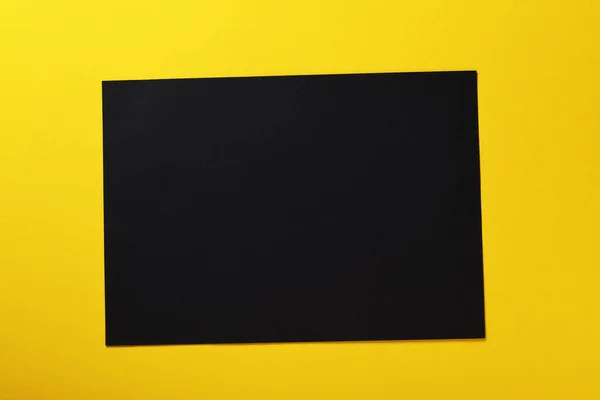 Una Hoja Papel Negro Sobre Fondo Amarillo — Foto de Stock