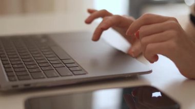 Bu resim, parlak, modern bir çalışma alanında, üretkenliği ve yaratıcılığı vurgulayan ve dijital ortamda yenilikçi düşünmeyi teşvik eden şık bir dizüstü bilgisayarda yazı yazan elleri gösteriyor.