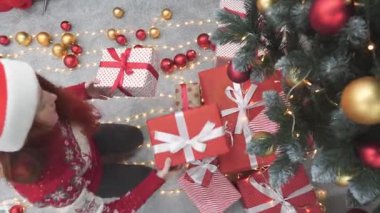 Noel 'in ruhunu somutlaştıran süslü bir Noel ağacının altında güzel paketlenmiş hediyelerle dolu neşeli bir kutlama sahnesi.