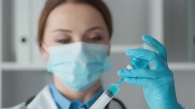 Bir laboratuvar teknisyeni titizlikle mavi sıvı çözümleri ölçüyor ve hazırlıyor, bilimsel araştırma ve analizlerde hassasiyet gösteriyor. Atmosfer kimyaya odaklanmayı vurguluyor..