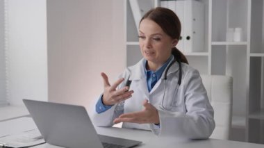 Şefkatli bir tıp uzmanı, dijital bir cihaz vasıtasıyla hastayla sağlık sorunlarını tartışırken empati ve iletişim becerilerini gösteren çevrimiçi bir konsültasyon yapar.