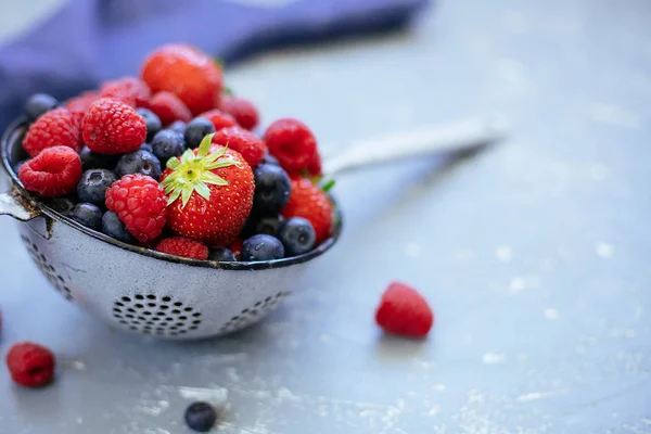 Organic fresh harvested berries. Mix of fresh juicy berries in colander, closeup