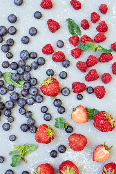 Смесь свежих сочных ягод на голубом фоне, вид сверху — стоковое фото