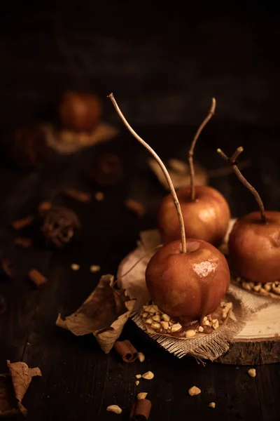 Old fashioned toffee apples with twig sticks. Autumn mood background.