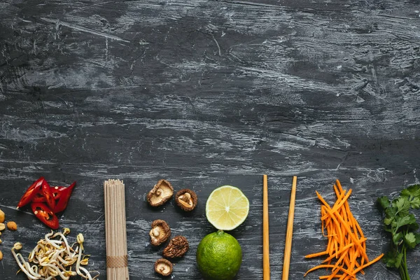 Ingredientes para plato asiático. Fideos de soba asiáticos secos con diferentes ingredientes sobre fondo de madera con espacio para copiar . —  Fotos de Stock