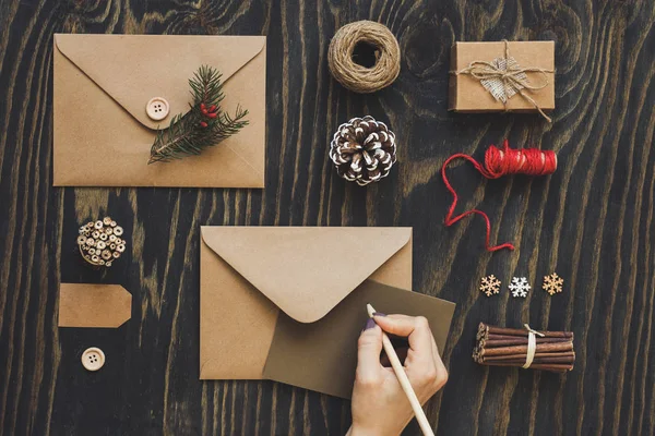 El yapımı yılbaşı kartları ve hediye. El ahşap masa, üstten görünüm Noel kartı yapma