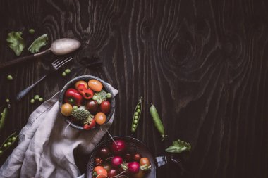 Taze organik sebze salatası. Yeşil bezelye, brokoli, domates, turp ahşap masa üzerinde. Üstten görünüm.