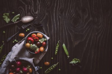 Taze sebze salatası. Yeşil bezelye, brokoli, domates, turp ahşap masa üzerinde. Üstten görünüm.