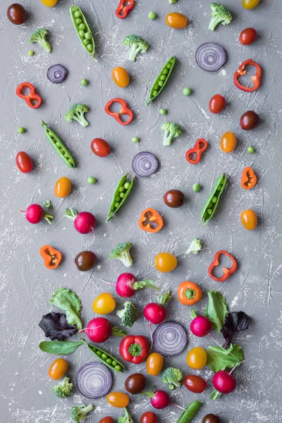 Tiszta táplálkozás koncepció. Friss organikus zöldségek. Retek, zöldborsó, brokkoli, paradicsom és hagyma, a szürke háttér. — Stock Fotó