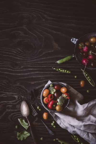 新鮮な有機野菜。グリーン ピース、ブロッコリー、トマト、木製のテーブルで大根。トップ ビュー. — ストック写真