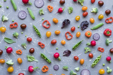 Temiz kavramı yeme. Taze organik sebze. Turp, yeşil bezelye, brokoli, domates ve soğan gri arka plan üzerinde. 