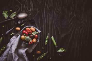 Taze organik sebze salatası. Yeşil bezelye, brokoli, domates, turp ahşap masa üzerinde. Üstten görünüm.