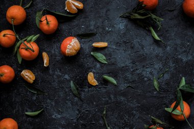 Olgun mandalina ile dokulu koyu arka plan kopya alanı ile yapraklarda. Üstten görünüm.