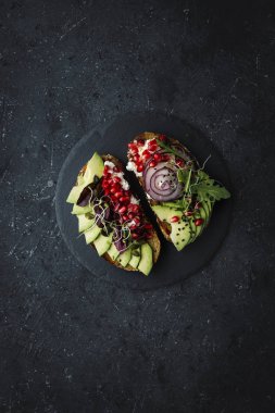 Sağlıklı gıda. Avokado avokado dilimleri ile tohum kızartır ve koyu arka plan üzerinde lahanası.