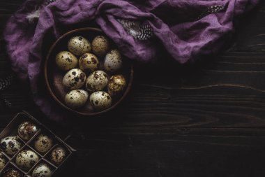 Koyu ahşap arka plan üzerinde ahşap kase organik bıldırcın yumurtası. Kopya alanı ile.