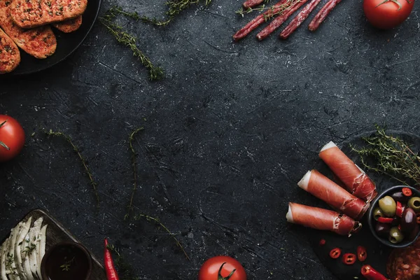 Akdeniz meze karışımı. Jamon, chorizo, fuet ve hamsi filetosu kopya alanı ile koyu arka plan üzerinde.