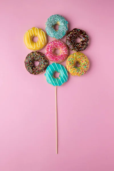 Donuts coloridos em fundo rosa . Fotos De Bancos De Imagens