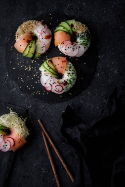 Karanlık arka planda suşi çörekleri. Üstte görüntü.