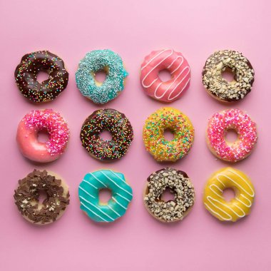 Renkli tatlı arka plan. Pembe arka planda lezzetli sırlı donutlar. 