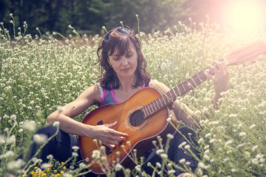 Tonda çimenlerde yalan gitar ile kız.