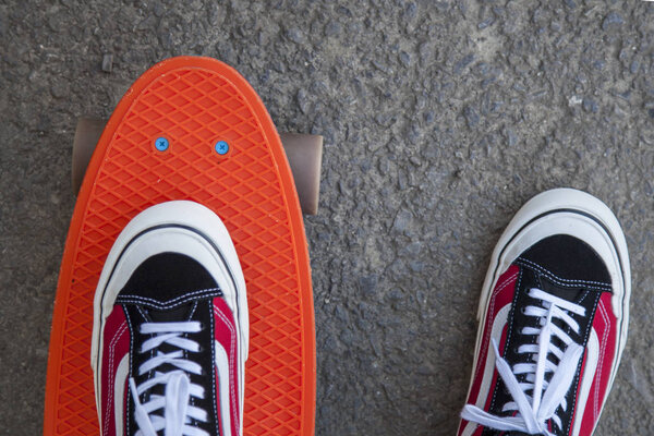 Urban scene, city life. Sport, fitness lifestyle, penny skate board, red sneakers