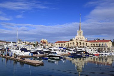 Sochi, Rusya Federasyonu-25 Aralık 2017:Marine Sochi İstasyonu, Havana Sochi sea Port arka plan deniz istasyonu/görünüm Harbor Sochi liman ve deniz Gar binası üzerinde küçük bir Yelkenli tekne