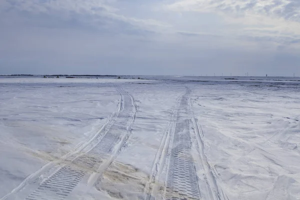 Traces from tracks of the cross-country vehicle; trail tracks from an all-terrain vehicle on snow