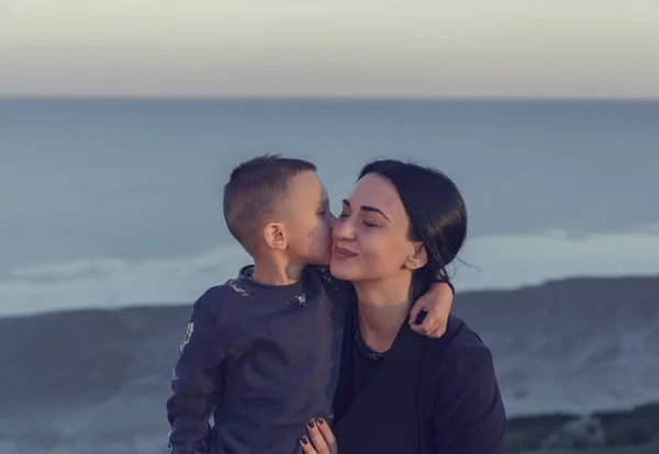 Mother's Day, Mom and Son, the boy hugs Mom, who closed her eyes with happiness, tone