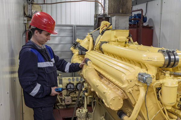 Electromechanic performs repair work on a diesel generator