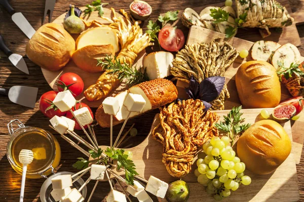 Traditional Italian Smoked cheese, Traditional Polish smoked cheese, Chechil cheese on the Wood background. Smoked cheese  on a cutting board, with grapes, basil, figs, a large assortment of cheeses