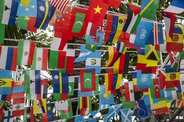 World flags,little flags of different countries, small flags of different countries stretched between palm trees