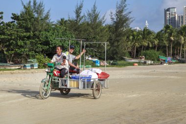 Çin, Hainan Adası, Sanya bay - 2 Aralık 2018: defne, Çince üç tekerlekli bisiklet elektrik moped Sanya, Çin insanlar plajda bir şehir, editoryal elektrikli bir üç tekerlekli bisiklet üzerinde