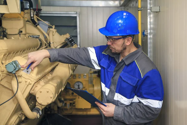 Electromecánico realiza trabajos de reparación en un generador diesel — Foto de Stock