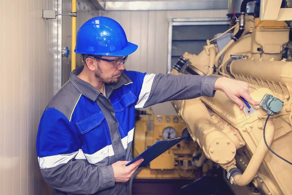 Electromecánico realiza trabajos de reparación en un generador diesel — Foto de Stock