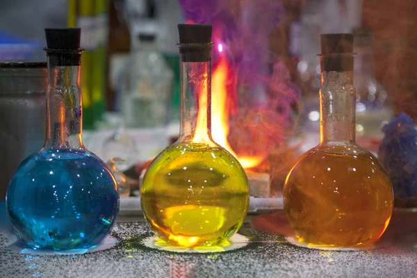 chemical laboratory, flasks with colored reagents, red smoke fro