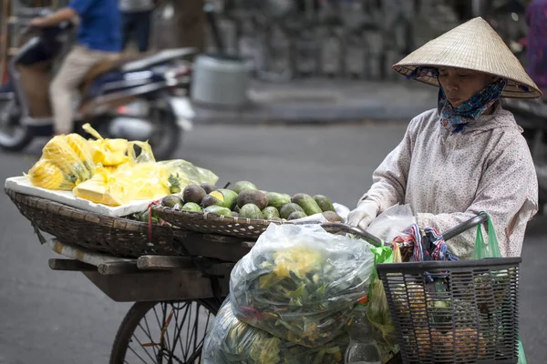 Hanoi régi negyedében. Utcai eladók eladni gyümölcsöt a biciklit — Stock Fotó