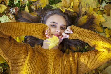Sarı kazak güzel kız sarı ile çim üzerinde yatıyor