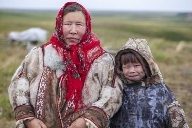En kuzeyde Yamal, Nenets halkının geçmişi, kuzeydeki insanların evleri, tundrada yurt yakınlarında bir aile fotoğrafı.