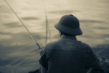 Nehir, renkli gri bir olta ile arkadan bir balıkçı profili