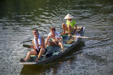 Ninh Binh, Vietnam, 2019-06-20: Tam Coc Milli Parkı, dağların arasında pirinç tarlalarının güzel manzarası, dağın tepesinden manzara, turistler uzun teknelerle nehirüzerinde binmek, nehir mağaraları turu