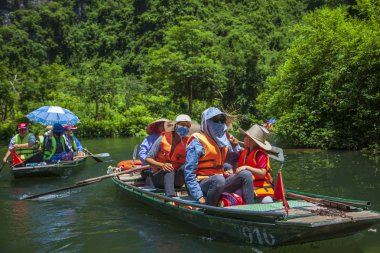 Ninh Binh, Vietnam, 2019-06-20: Tam Coc Milli Parkı, dağların arasında pirinç tarlalarının güzel manzarası, dağın tepesinden manzara, turistler uzun teknelerle nehirüzerinde binmek, nehir mağaraları turu
