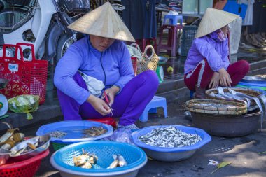 Hoi An, Vietnam - 12 Haziran 2019: Hoi An Old Market, geleneksel Vietnam saman kapaklar ticaret piyasada kadınlar