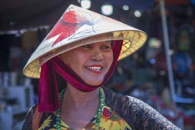 Hanoi, Vietnam - 28 Haziran 2019: Hanoi'nin eski mahallesi. Sokak satıcıları geleneksel şapka, closeup portre kendi bisiklet meyve satmak.