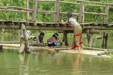 Kedi köyü, üç küçük kız gölde sala biniyor.