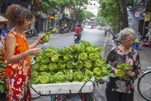 O velho bairro de Hanoi. Mulheres vietnamitas, vendedores de frutas vestindo t — Fotografia de Stock